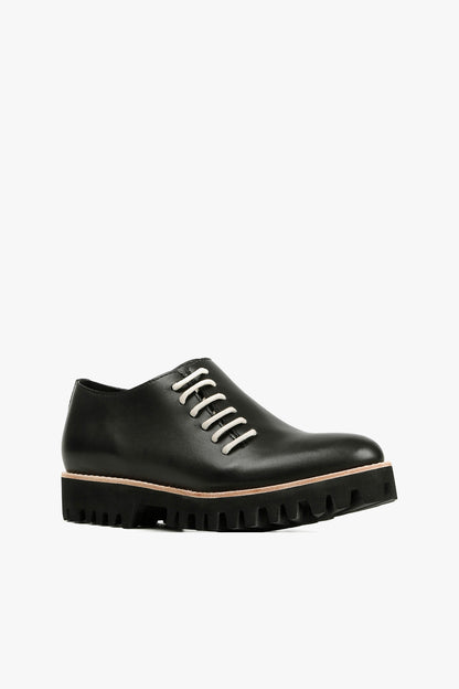 Women's black leather lace-up oxfords with contrast white round laces, natural welt detail, and chunky black lug sole side view