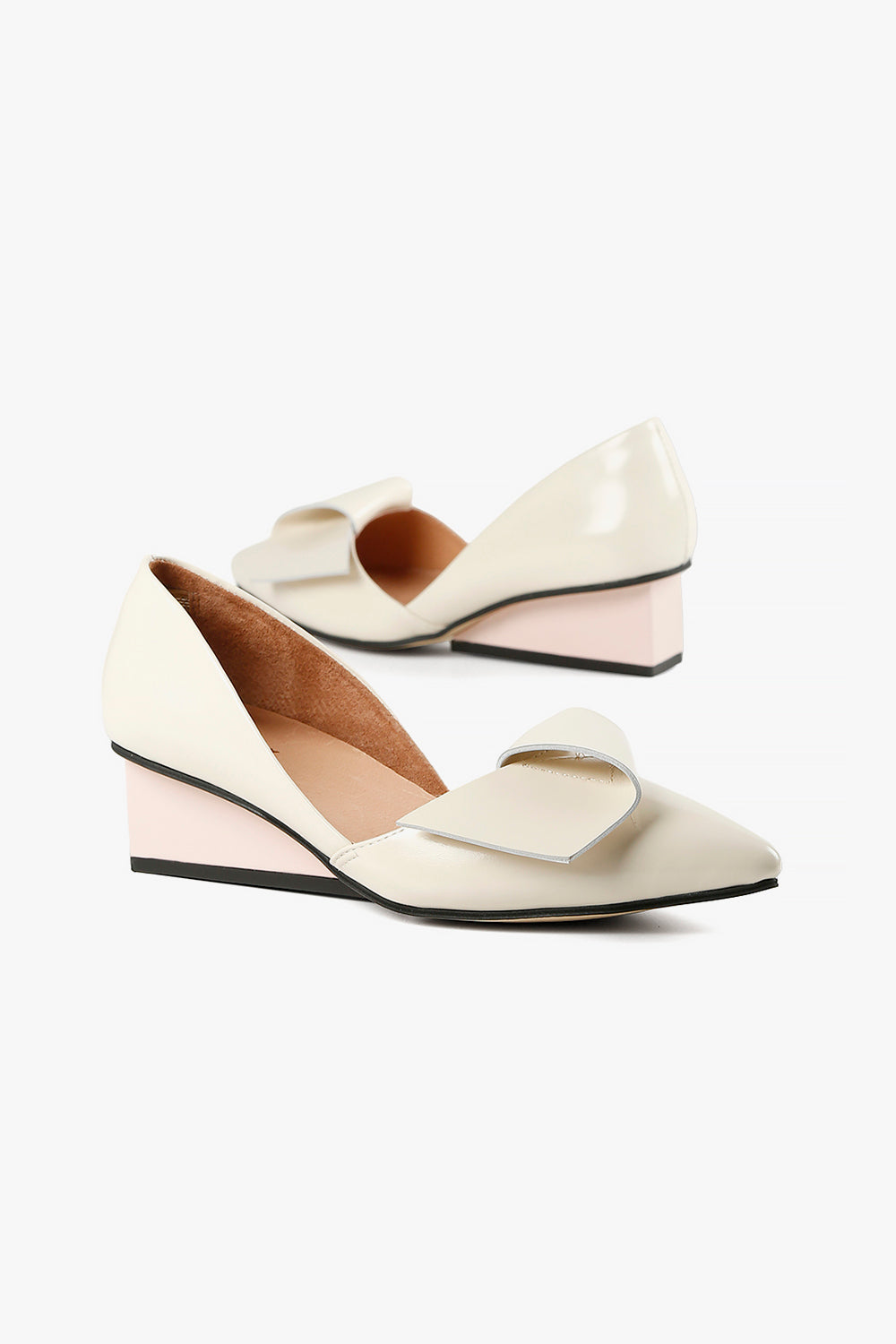 Women's cream leather pointed-toe heels with ivory sculptural wedge and asymmetrical bow accent.