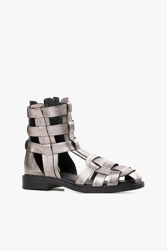 Women's metallic pewter leather gladiator sandals with wide woven straps and high ankle coverage side view.