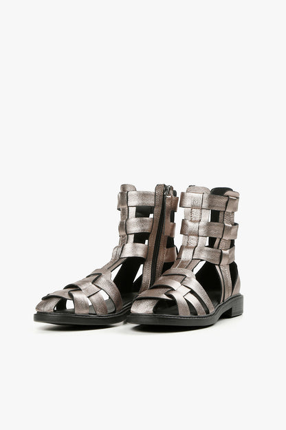 Pair of women's shimmering pewter cage sandals featuring a modern woven design and black flat sole.