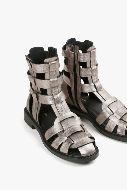 Top view of women's pewter metallic gladiator shoes showcasing the intricate leather weave and interior gold branding.