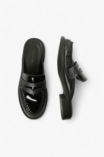 Close-Up of Patent Leather and Penny Loafer Strap Detail on Women’s Black Mules