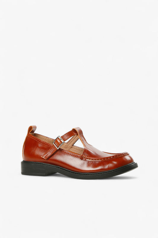 Women's brown leather T-strap Mary Jane shoes with silver buckle and black rubber sole side view.