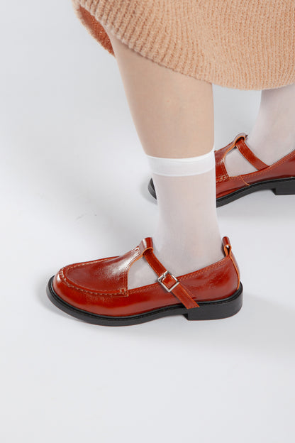 Lifestyle view of brown leather T-bar shoes styled with white socks for a modern preppy look.