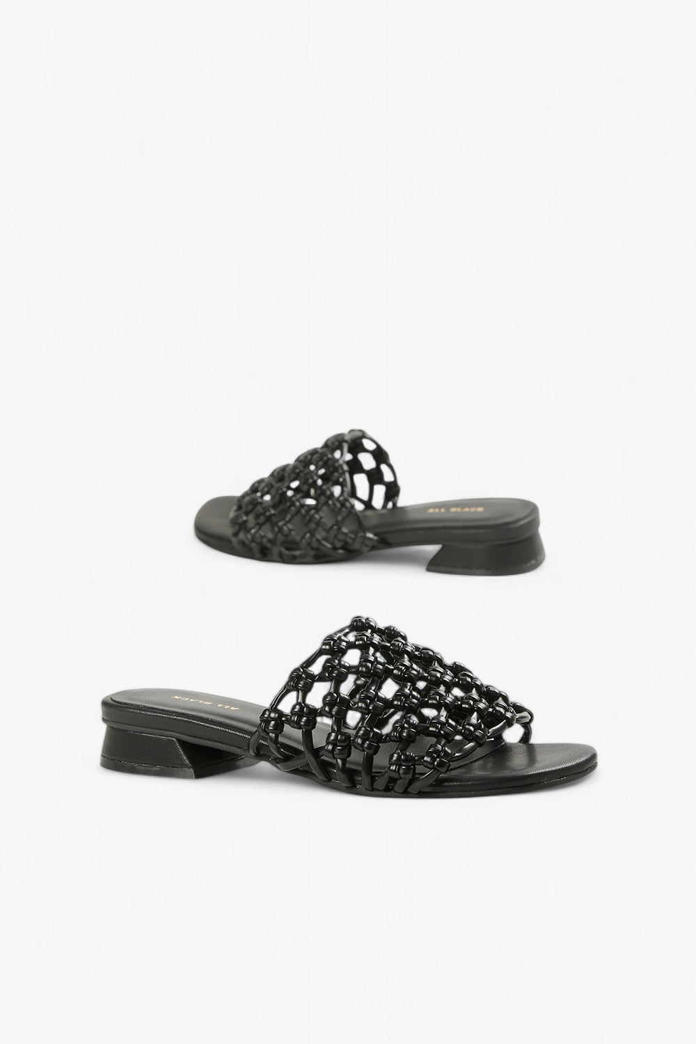 Pair of women's all-black leather slides featuring an intricate 3D square weave strap and low heel.