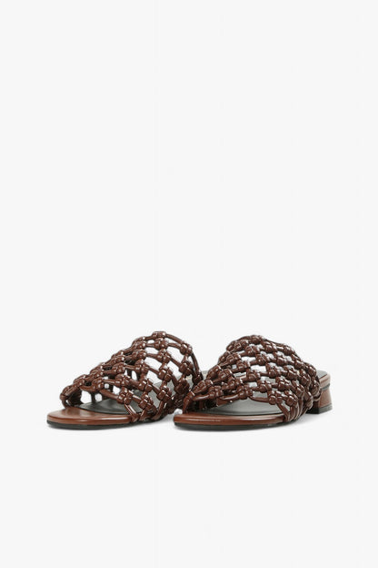 Women's coffee-colored open-toe sandals with architectural low heel and artisanal woven detail.