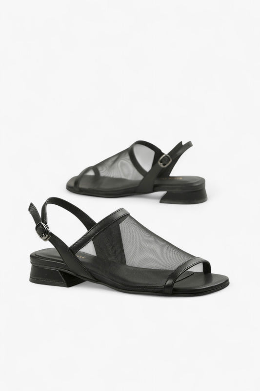 Pair of women's all-black open-toe sandals featuring transparent mesh upper and modern low heel.