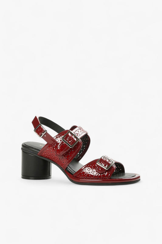 Women's burgundy patent leather sandals with triple buckle straps, laser-cut details, and black block heel side view.