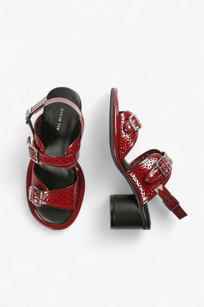 Top and side view of women's burgundy patent slingbacks with decorative perforations and silver hardware buckles.