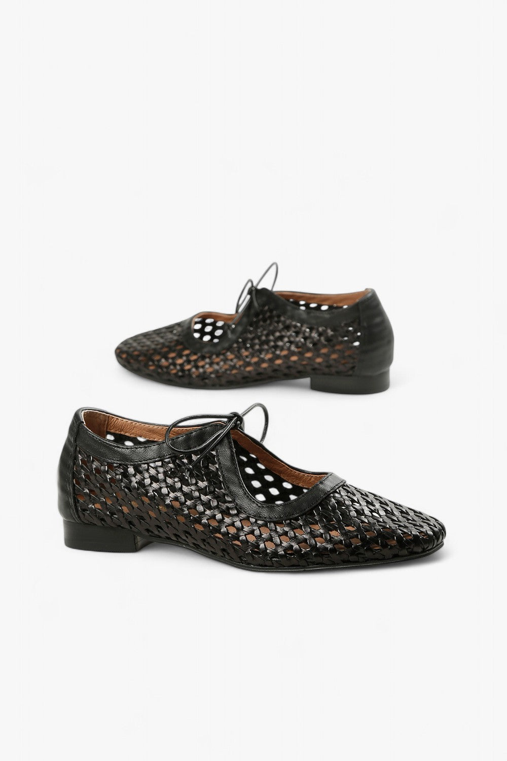 Pair of women's black huarache-style pointed toe flats featuring an intricate lattice weave and delicate laces.