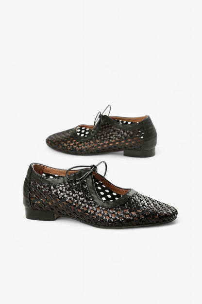 Pair of women's black huarache-style pointed toe flats featuring an intricate lattice weave and delicate laces.