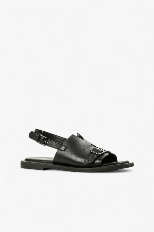 Women's black leather flat sandals with adjustable buckle strap and decorative front belt detail side view.
