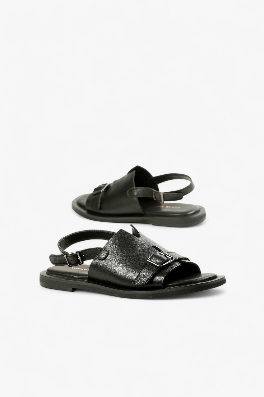 Pair of women's minimalist black leather slides featuring a V-cut upper and secure slingback strap.