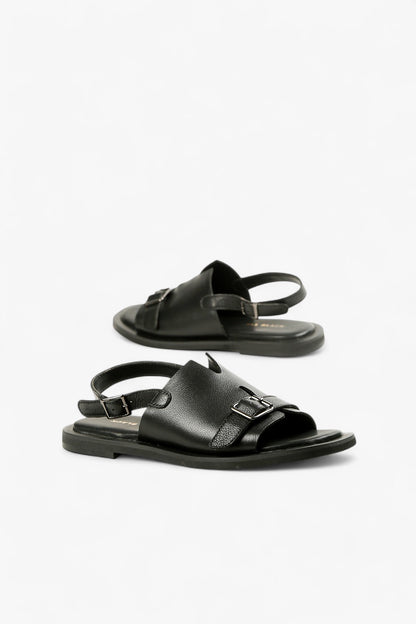 Pair of women's minimalist black leather slides featuring a V-cut upper and secure slingback strap.