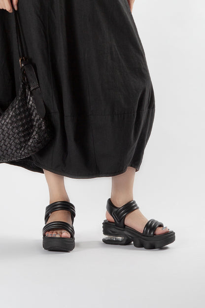 Lifestyle View of Women’s Black Leather Padded Strap Platform Sandals on Model