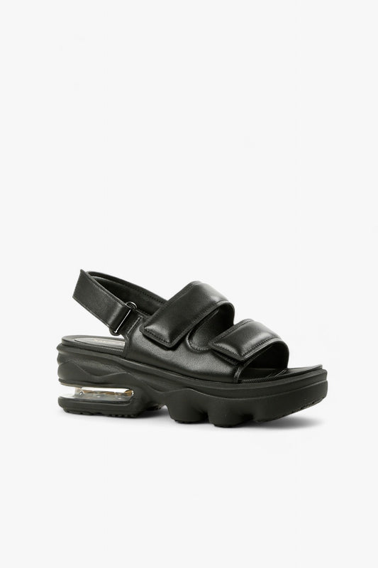 Women's black padded leather platform sandals with dual velcro straps and visible air cushion sole side view.
