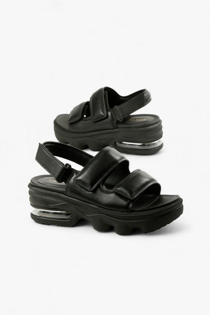 Pair of chunky women's black sporty sandals featuring a thick lug sole and transparent air bubble unit.