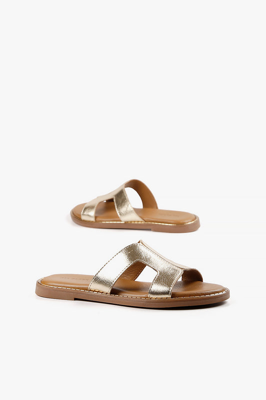 Pair of women's shimmering champagne gold slides featuring an architectural open-toe design.