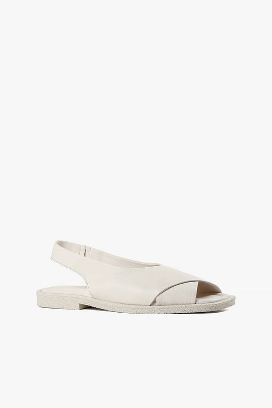 Women's white leather criss-cross slingback sandals with textured off-white platform sole side view.